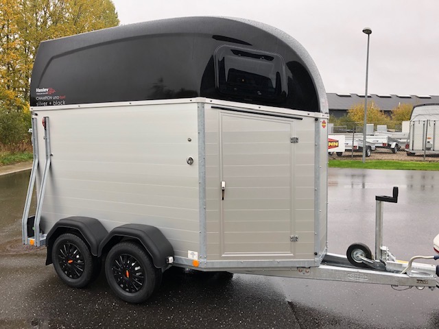 Eight shirts arranged on table in black, olive, grey, blue, white, red, mustard, and green.