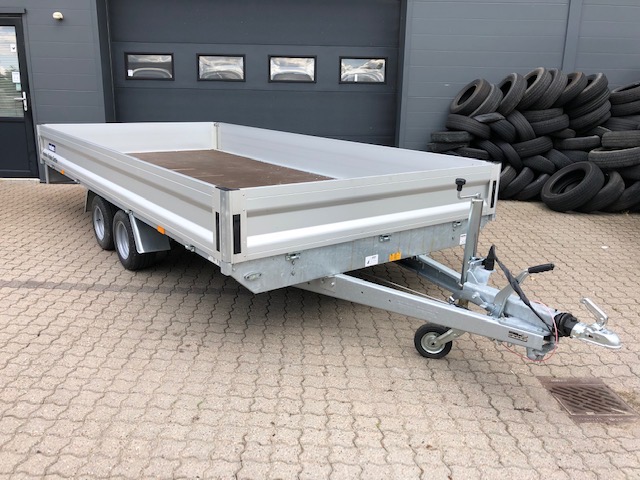 Eight shirts arranged on table in black, olive, grey, blue, white, red, mustard, and green.