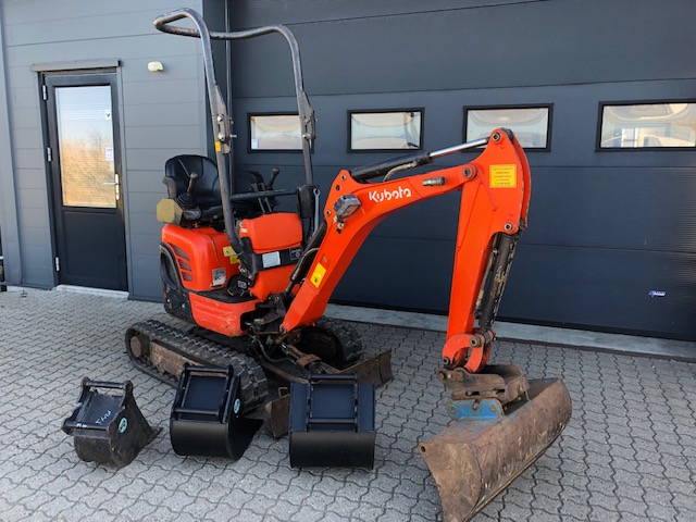 Eight shirts arranged on table in black, olive, grey, blue, white, red, mustard, and green.