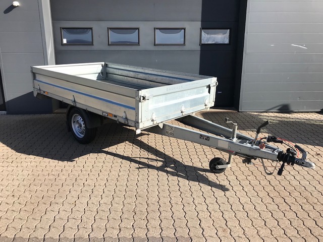 Eight shirts arranged on table in black, olive, grey, blue, white, red, mustard, and green.