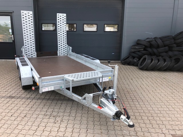 Eight shirts arranged on table in black, olive, grey, blue, white, red, mustard, and green.